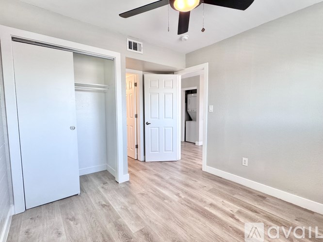 A room with a ceiling fan and a white door.