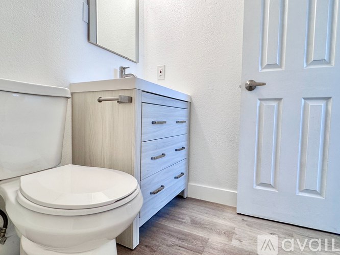 A white toilet with a white cabinet and a white door in a bathroom.