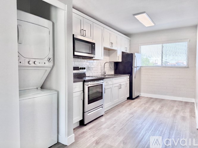 A kitchen with white appliances and cabinets.