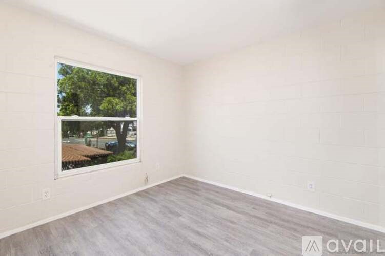 A room with a large window showing an outdoor scene.