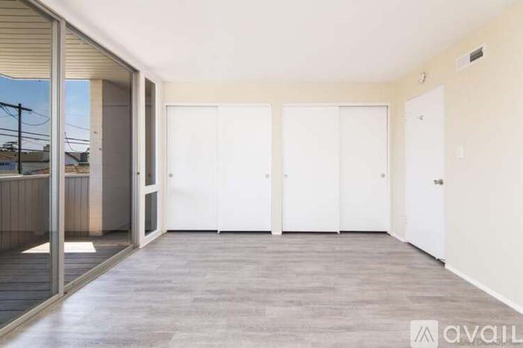 A room with white doors and a grey floor.