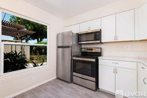 A kitchen with white cabinets and stainless steel appliances.