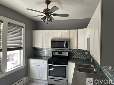 A kitchen with a fan and a stove top oven.