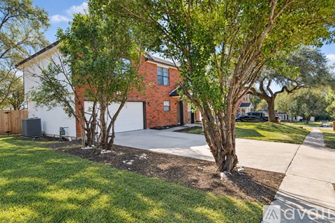 A red brick house with a white garage door.