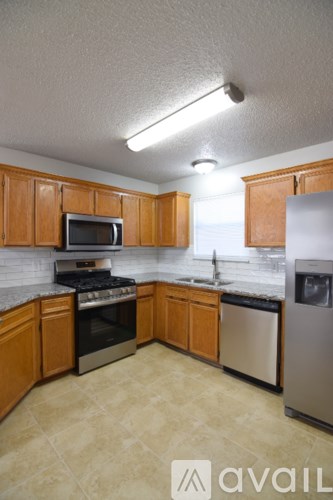 A kitchen with wooden cabinets and a stainless steel dishwasher.