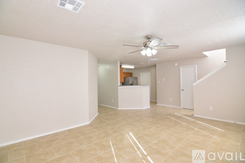 A spacious room with a fan and a counter in the background.