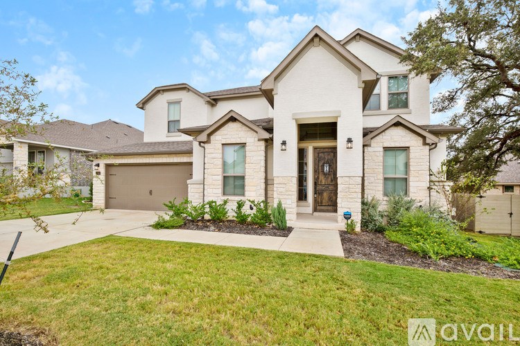 A large, two-story house with a front yard and a driveway.
