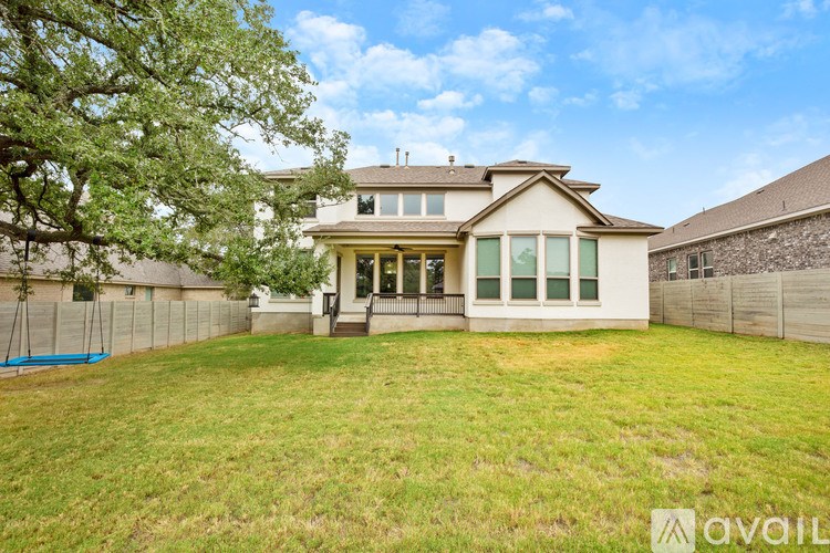 A house with a large front yard and a tree in the front.