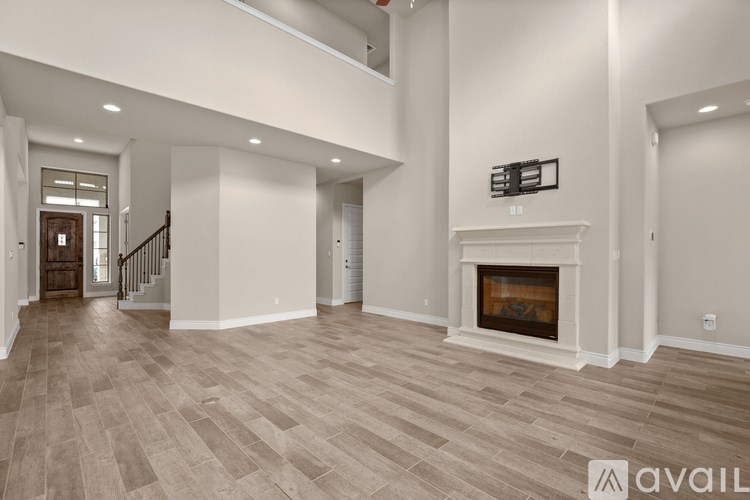 A spacious living room with a fireplace and wood flooring.