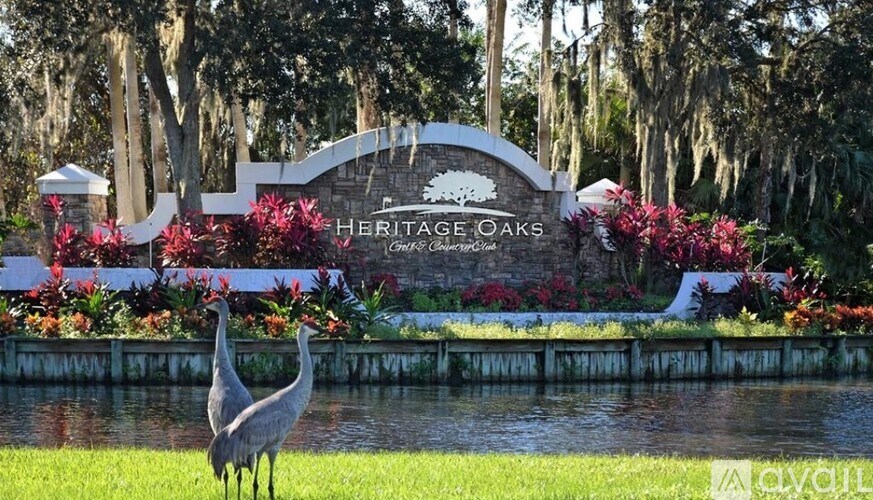 A heritage oaks sign with a crane in front of it.
