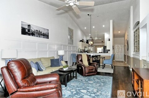 A living room with a brown leather chair and a blue patterned rug.