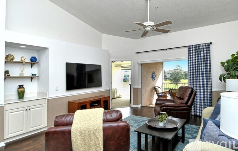 A living room with a brown leather couch and a television.