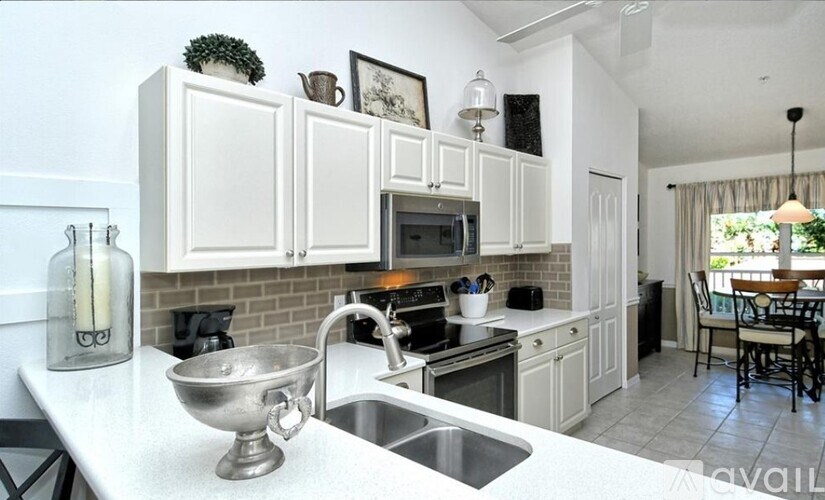 A kitchen with white cabinets and a black stove top.