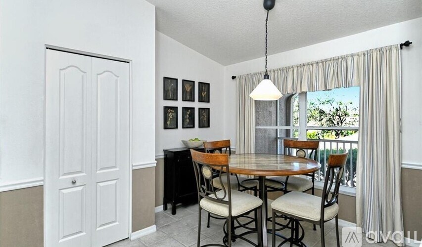 A dining room with a table and chairs.