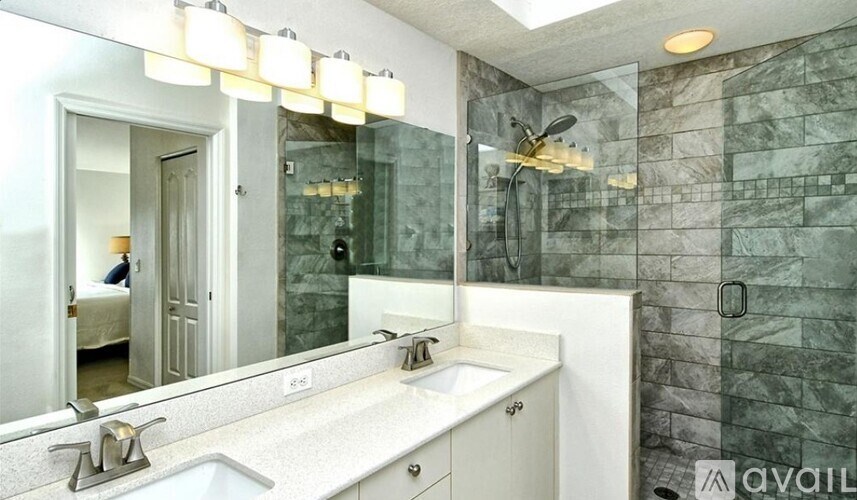 A bathroom with a marble wall and a white sink.