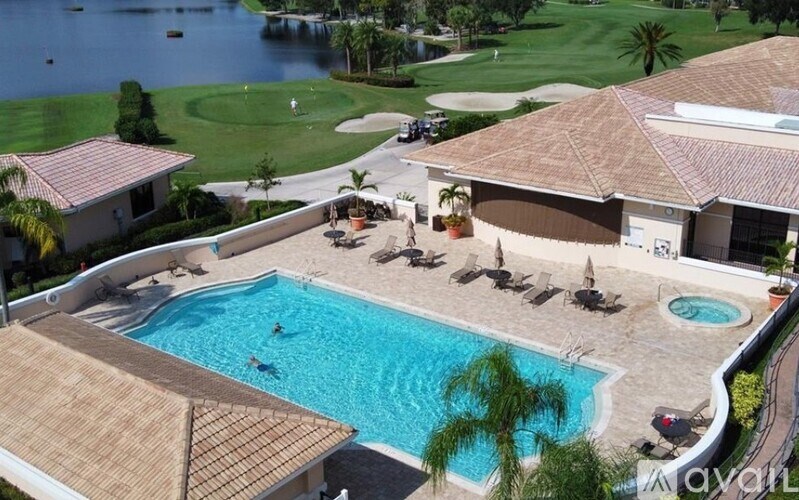 A large house with a pool and a golf course in the background.