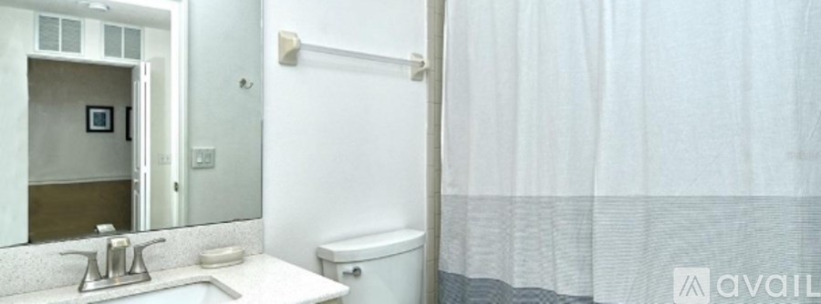 A bathroom with a toilet, sink, and shower curtain.