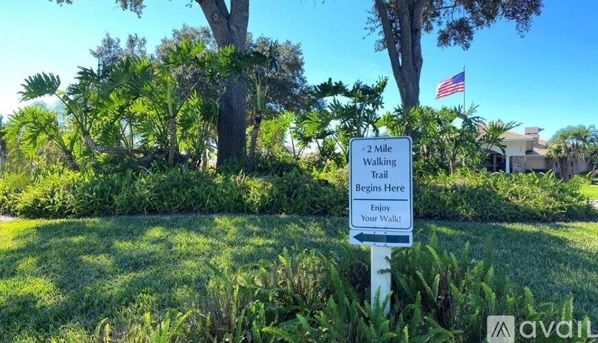 A sign in a grassy area indicates the beginning of a 2-mile walking trail.