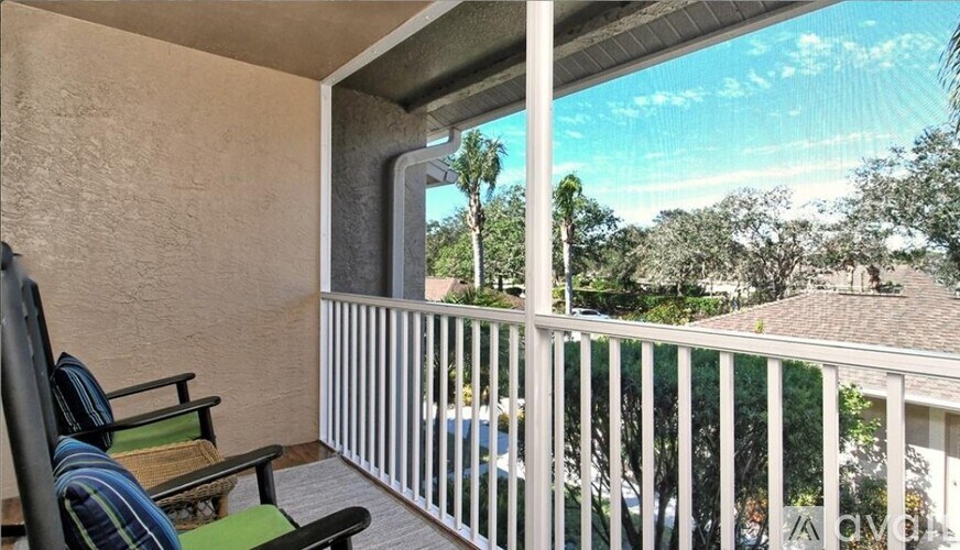 A balcony with a chair and a table.