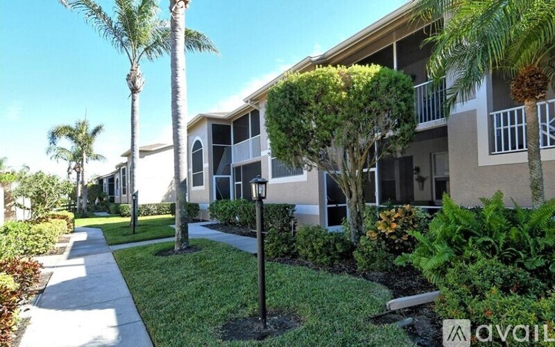 A row of houses with a sidewalk and greenery.