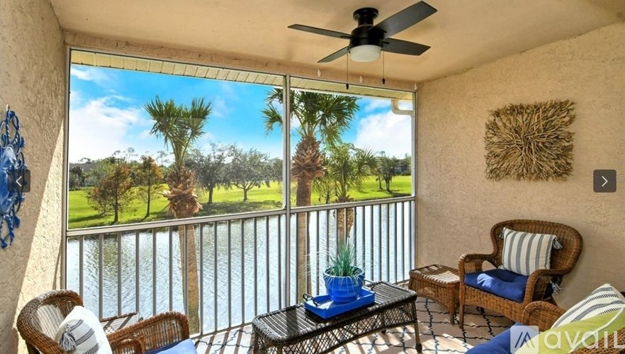 A balcony with a table and chairs overlooking a body of water.