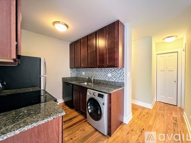 A kitchen with wooden cabinets and a granite countertop.