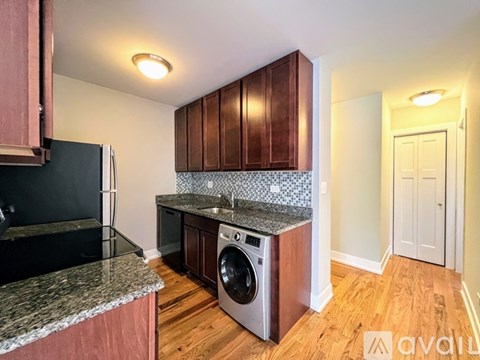 A kitchen with wooden cabinets and a granite countertop.