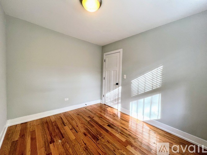 A room with wooden flooring and a white door.