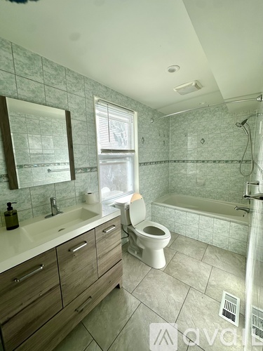 A bathroom with a toilet, sink, and bathtub.