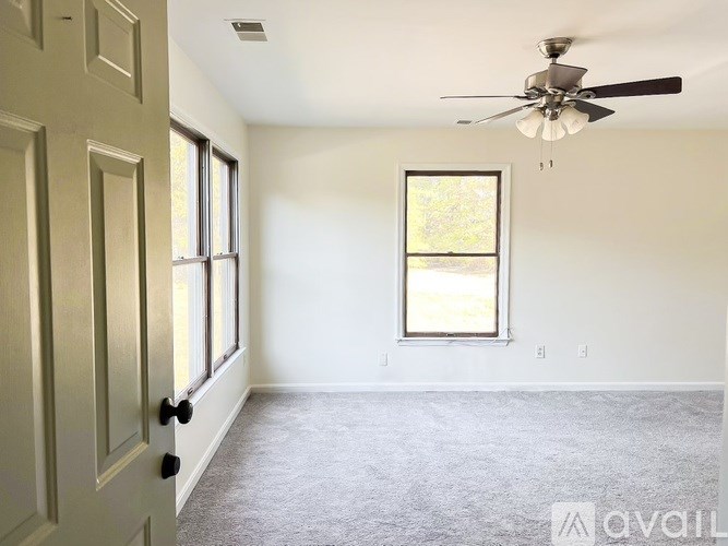 A room with a ceiling fan and a window.