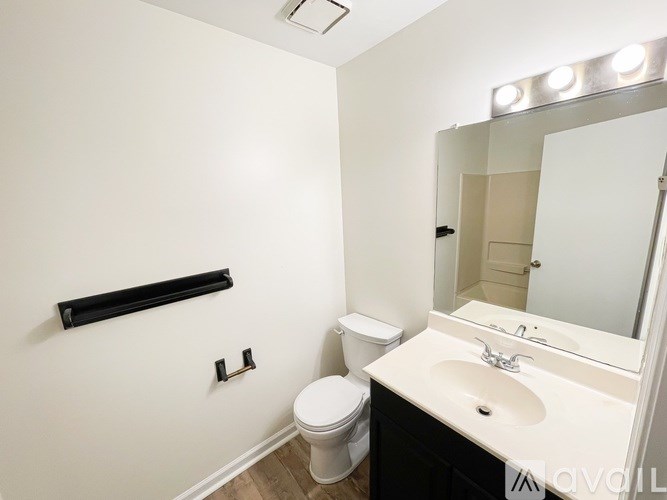 A white sink is in a black vanity with a mirror above it.