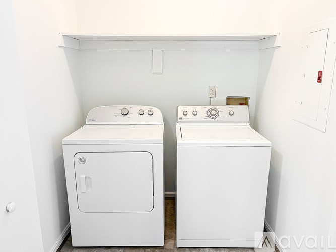 Two white front loading washing machines in a laundry room.