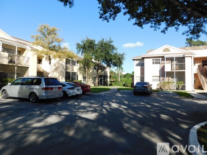 A row of townhouses with cars parked in front.
