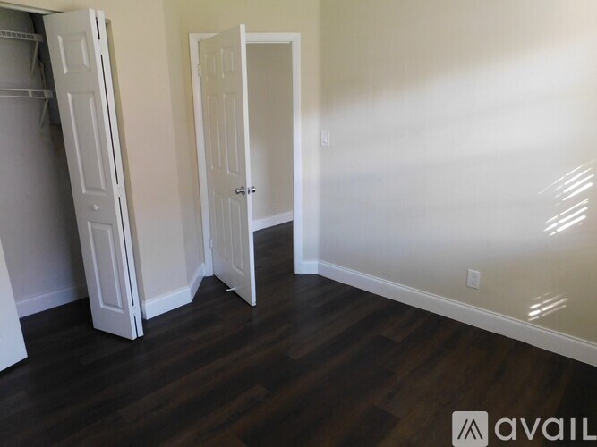 A room with a white door and a white closet with a white shelf.