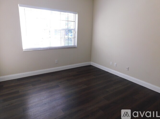 A room with a window and wooden flooring.
