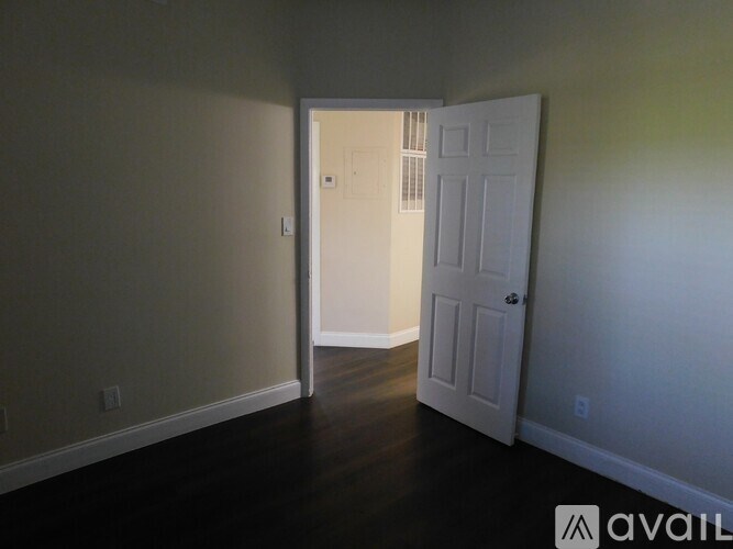 A room with a white door and a wall socket.