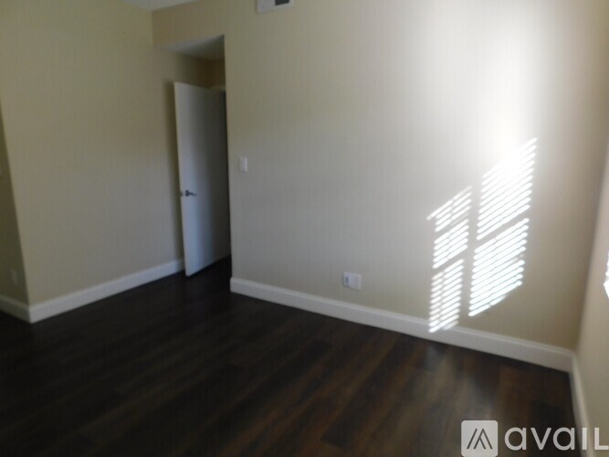 A room with wooden floors and a wall with a window.