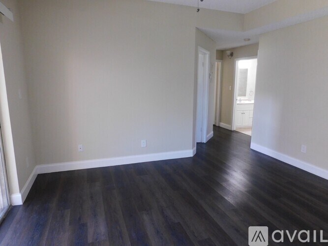 A room with wooden flooring and white walls.
