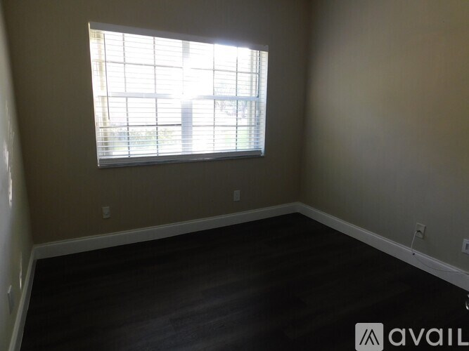 A room with a window and wooden flooring is available for rent.