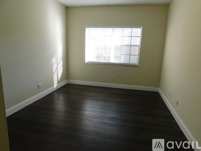 A room with a window and wooden flooring.