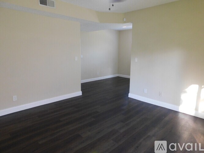 A room with wooden flooring and white walls.