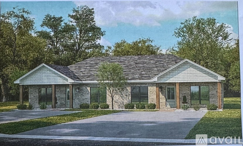 A house with a grey roof and a stone pillar in front.