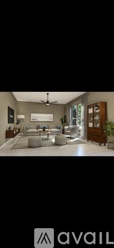 A modern living room with a large sofa and a ceiling fan.