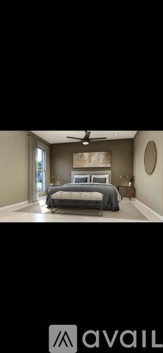 A bedroom with a bed, a ceiling fan, and a mirror on the wall.