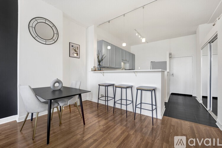 A modern dining area with a black table and white chairs.