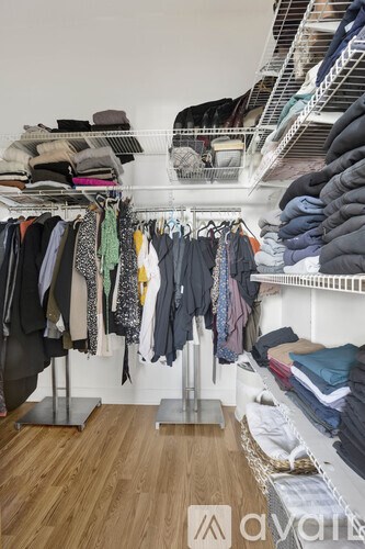 A room with a lot of clothes hanging on a rack.