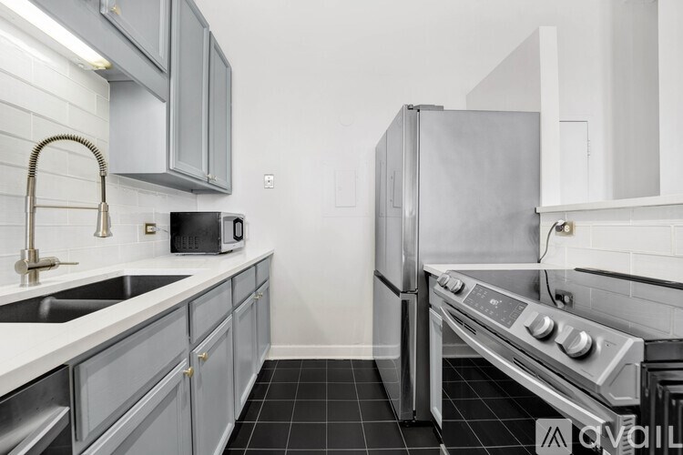 A modern kitchen with a stainless steel refrigerator and oven.