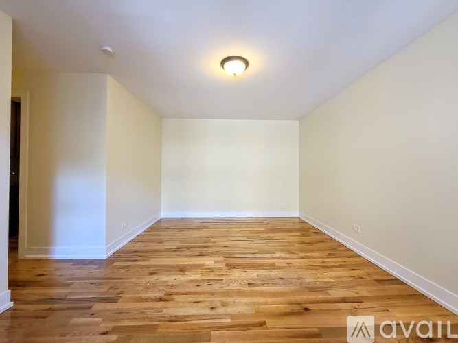 A room with wooden flooring and white walls.