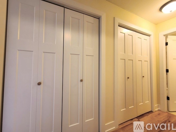 A row of white doors in a hallway.