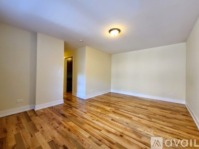 A room with wooden flooring and a ceiling light.